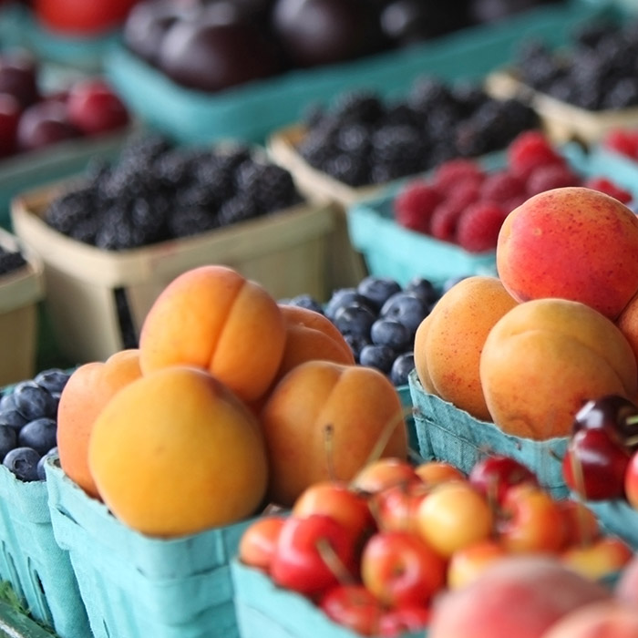 Colorful fruits sit on a table waiting to be purchased and eaten.