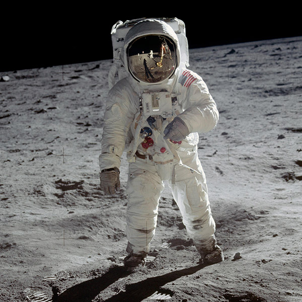 An astronaut stands for a photo on the moon's surface.